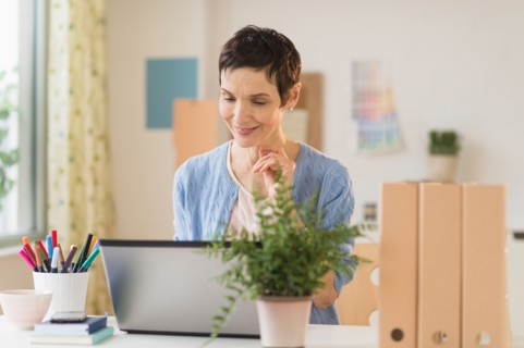 Woman using laptop in home office.