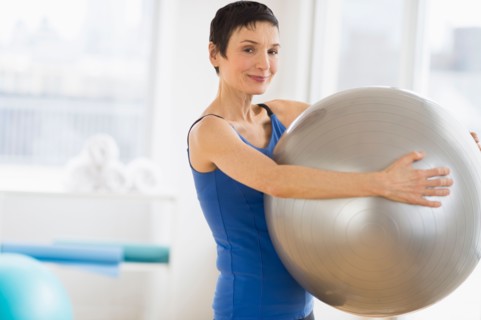 Portrait of mature woman exercising in gym.