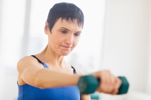 Mature woman exercising in gym.