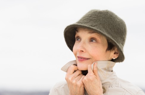 Portrait of smiling woman wearing raincoat and hat.