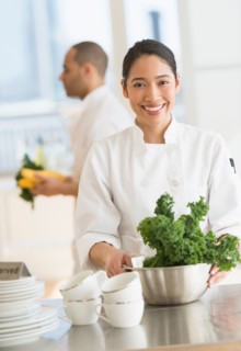 Couple during preparations in kitchen of their own restaurant.