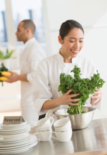 Couple during preparations in kitchen of their own restaurant.