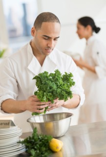 Couple during preparations in kitchen of their own restaurant.