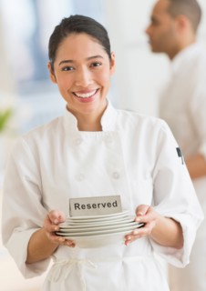 Couple during preparations in kitchen of their own restaurant.