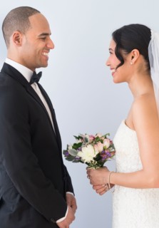 Bride and groom standing face to face.