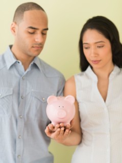 Young couple holding piggy bank.