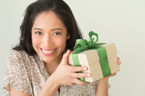 Young woman holding wrapped gift.