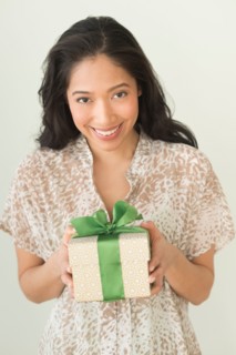 Young woman holding wrapped gift.