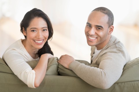 Portrait of young couple sitting on couch.