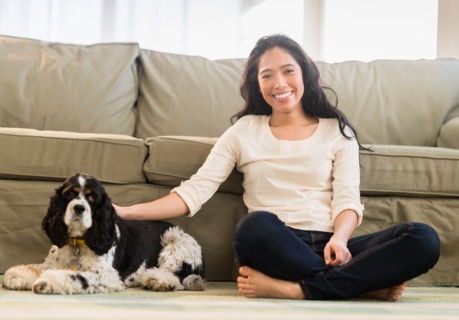 Young woman with dog in livingroom.