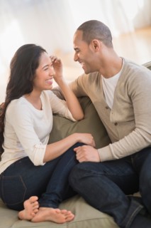 Portrait of young couple sitting on couch.