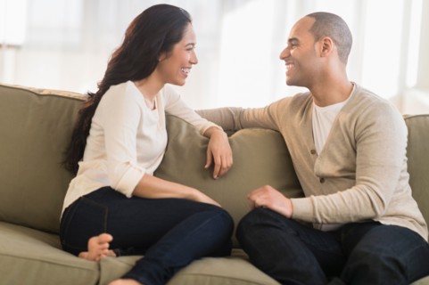Portrait of young couple sitting on couch.