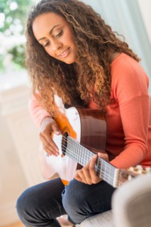 Young woman playing guitar.