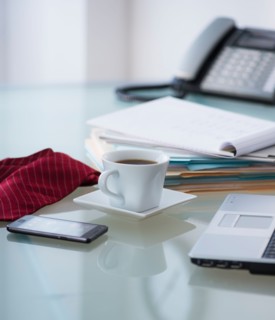 Close-up of coffee, paper material , tie, mobile phone and laptop