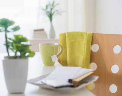 View of mug, flower pot, mobile phone, key and paper on table