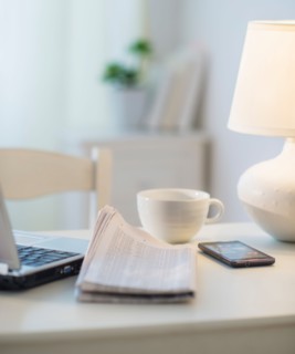 View of newspaper, laptop, mobile phone and cup