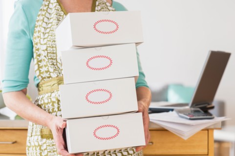 Mid section of woman carrying boxes