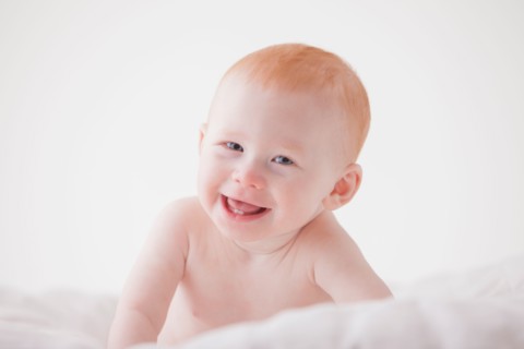 Portrait of baby boy (18-23 months) laughing