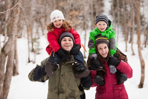 Portrait of parents carrying children (2-3, 4-5) on shoulders