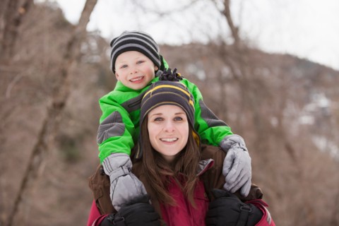 Portrait of young woman carrying boy (4-5) on shoulders