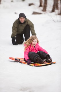 Young man sledding with girl (4-5)