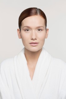 Studio shot portrait of young woman in bathrobe