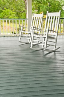 Two white rocking chairs on porch