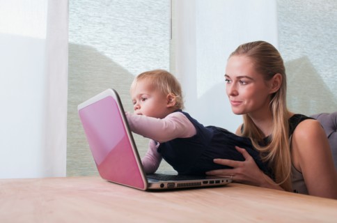 Baby girl (12-17 months) and mother using laptop