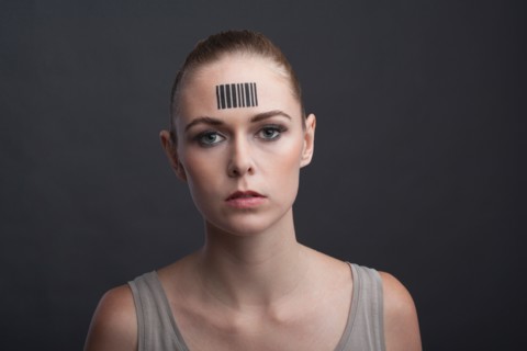 Studio portrait of woman with bar code on forehead