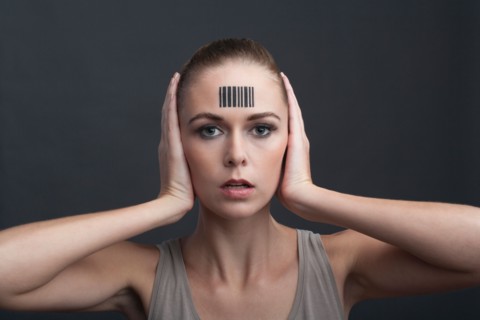 Studio portrait of woman with bar code on forehead
