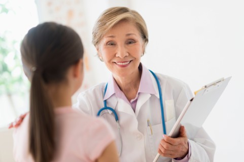 Portrait of doctor and girl (8-9) in foreground.