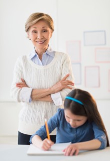 Teacher and schoolgirl (8-9) at school.