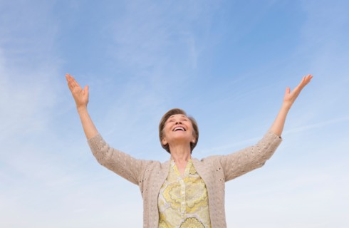 Senior woman looking up at blue sky.