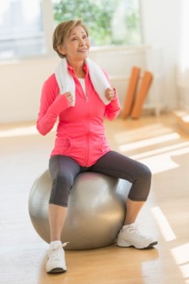 Senior woman exercising with fitness ball.
