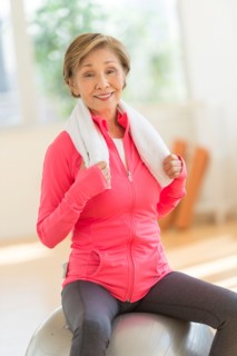 Senior woman exercising with fitness ball.