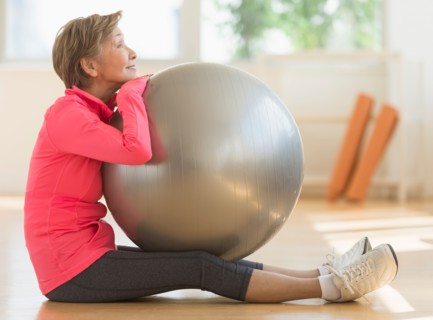 Senior woman exercising with fitness ball.
