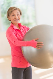 Senior woman exercising with fitness ball.