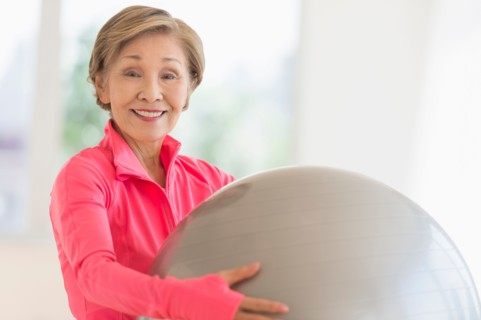 Senior woman exercising with fitness ball.