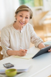 Senior woman using tablet pc at home.