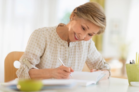 Senior woman writing in diary.