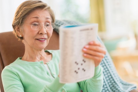 Senior woman doing crossword puzzle.