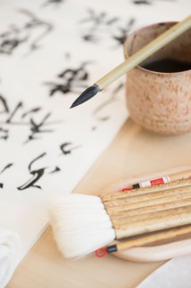 Calligraphy paintbrushes, ink and Japanese script.