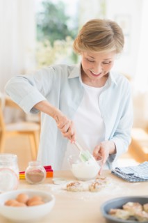 Senior woman cooking in kitchen.
