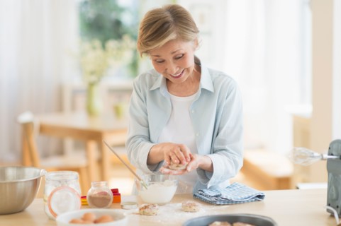 Senior woman cooking in kitchen.