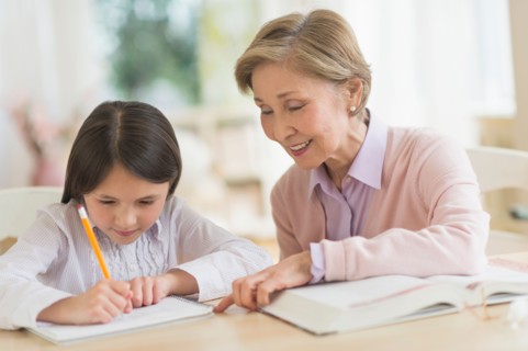Grandmother and granddaughter (8-9) doing homework.