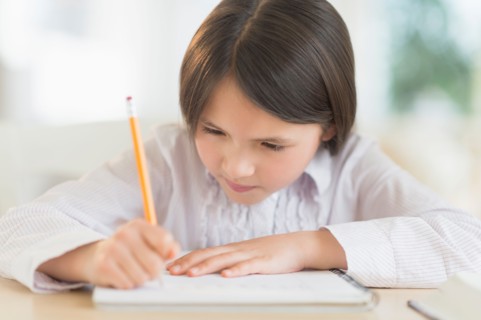 Girl (8-9) doing homework.