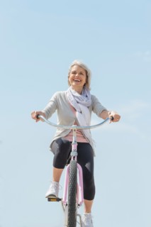 Senior woman riding bicycle.
