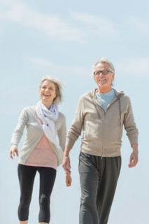 Senior couple walking and holding hands.
