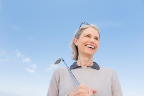 Senior woman holding golf club.