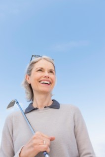 Senior woman holding golf club.